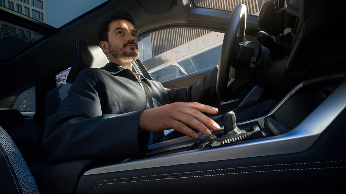 גבר נוהג ברכב היברידי של דאצ'יה